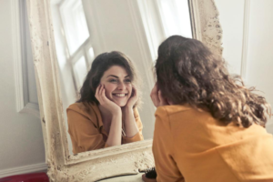 A Woman Looking for True Happiness Practices Smiling in the Mirror